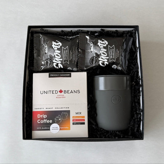 Coffee gift set with coffee beans and a mug in a black box on a light gray background